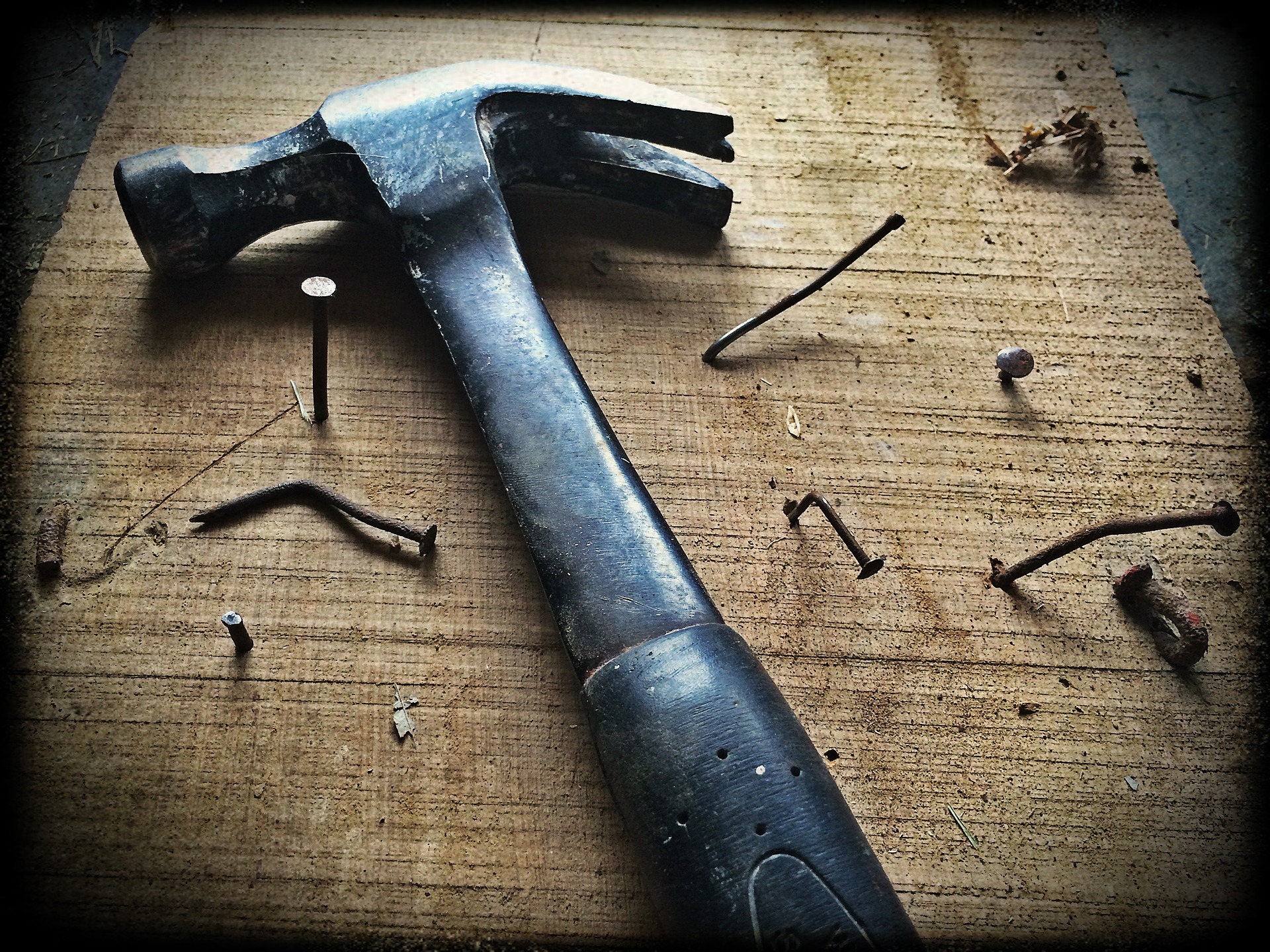 Hammer auf Arbeitsplatte mit Nägeln